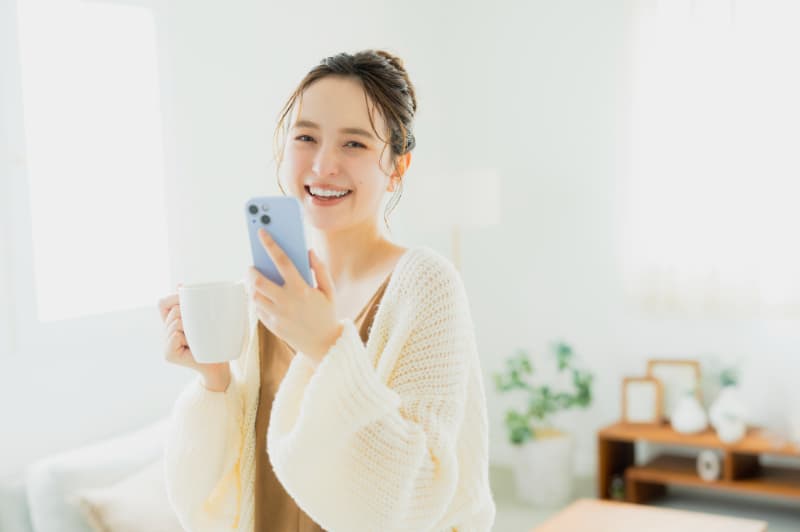 スマホを片手にリラックスする女性