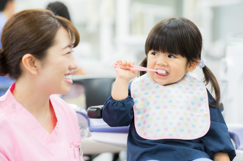 子どもの虫歯を予防するために歯科医院で正しいブラッシング指導をする歯科衛生士