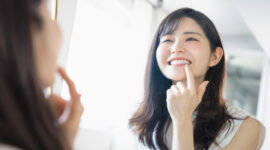 自分の歯を鏡でチェックする女性