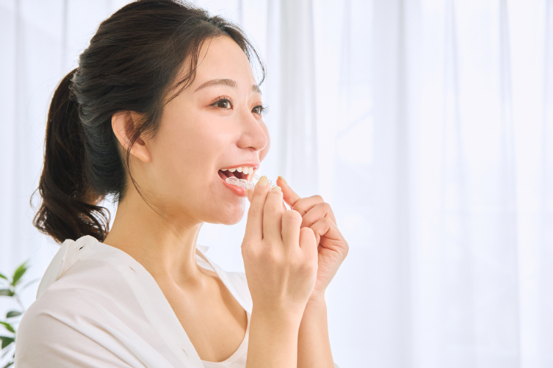 マウスピースで八重歯の矯正をする女性