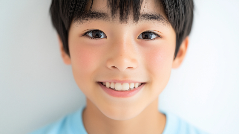 小児矯正で歯列が整い笑顔を見せる子ども