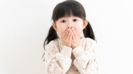 出っ歯が気になって口元を押さえる子供