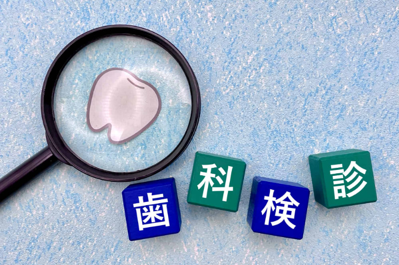 歯科検診の文字と歯をルーペで見るイメージ