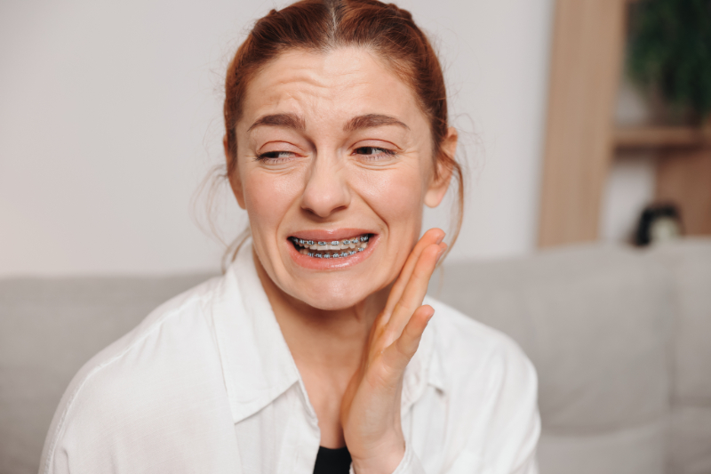 ワイヤー矯正中に痛みを感じる女性