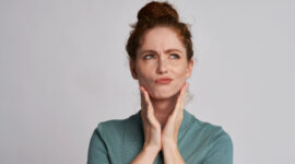 矯正治療中に痛みを感じるタイミングについて考える女性