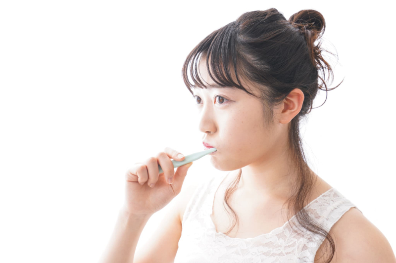 口臭予防に歯磨きを行う女性