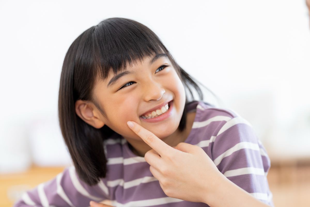 矯正を終えて綺麗な歯並びになった笑顔の女の子