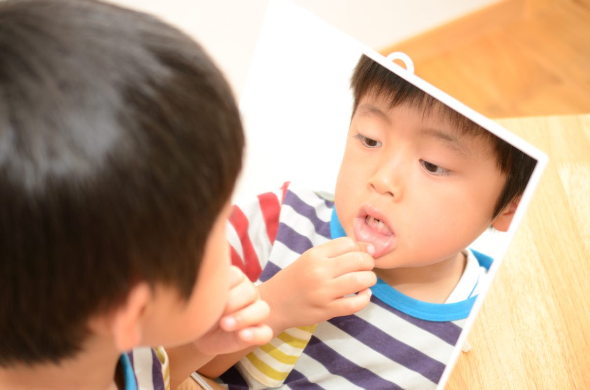 矯正後の歯並びを鏡で確認する男の子